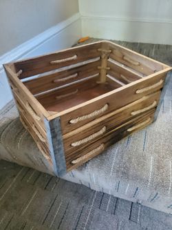 Rustic wooden crate made from solid wood with reinforced metal cornersRustic storage crate is constructed from solid wood with a dark stained finish.