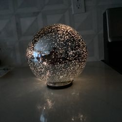 Silver twinkle light ball 8” (displayed on silver stand SOLD SEPARATELY) on/of/timer - loose battery chamber held by tape, but covered with rubber sea