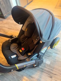 Doona Car Seat & Stroller combo in gray with a black interior