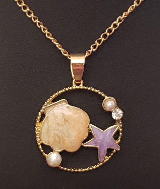 NEW Betsey Johnson Necklace. Gold and the Pendant has Enameled Beige Clam Shell, Purple Starfish, 2 Pearls and a Clear Rhinestones. Absolutely Beaut