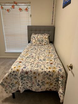 Twin bed with mattresses and fabric headboard