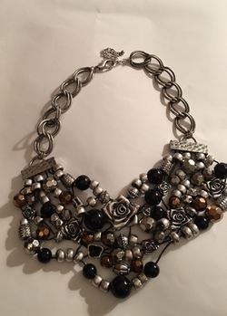 This is one of those WOW pieces! This necklace definitely is a show stopper - the mixture of silver, beads, roses, black, amber-brown and all the s