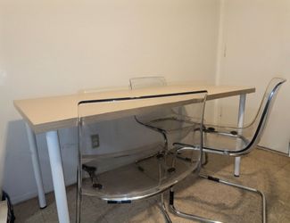 Clean long dinning table and three sturdy chairs