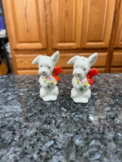Vintage White Dogs Pair of Salt and Pepper Shakers with Flowers and Bows.  Size approximately 3 inches tall.  Made in Japan stamped on the bottom Japa