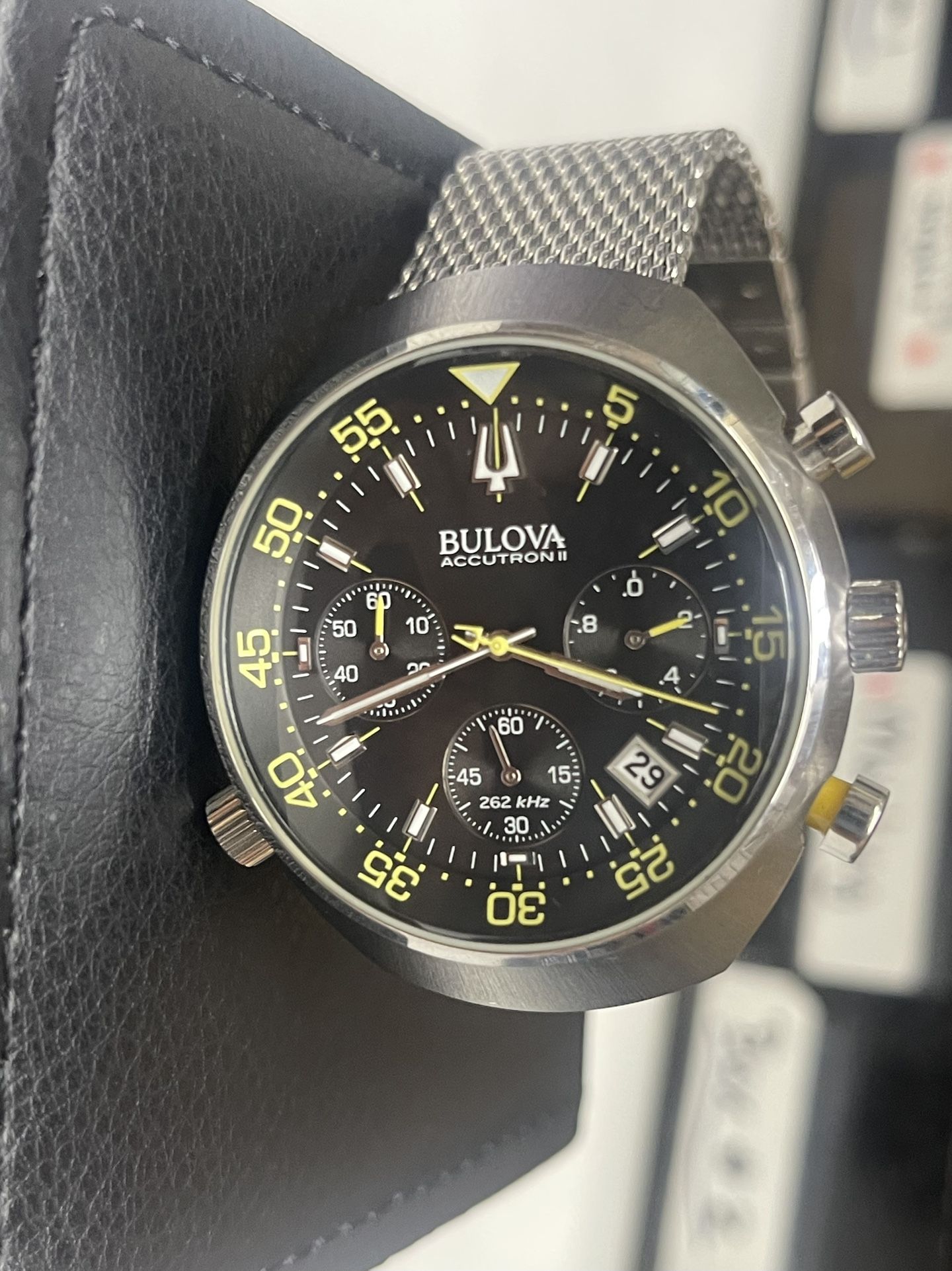 This is a Bulova Accutron II Lobster Chronograph watch with a black dial and a stainless steel mesh bracelet