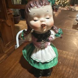 vintage ceramic figurine of a girl singing or yodeling