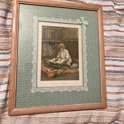 This lithograph, titled *The Little Librarian*, is a delicate and enchanting piece that measures 7” x 9”. It is presented in a wood frame with glass, 
