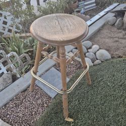 wooden bar stool with a brass footrest