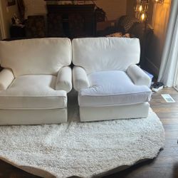 Two matching large white swivel rocking chairs