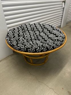 natural rattan papasan chair with a black and white chevron patterned cushion.