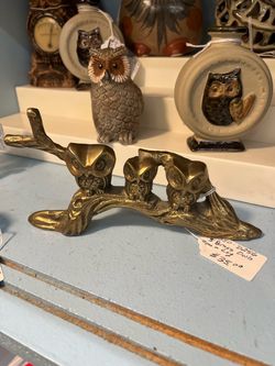 3 brass owls on a log