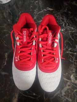 These are Under Armour Leadoff Mid RM baseball cleats in red and white.