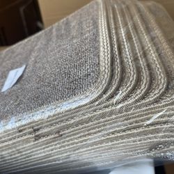 A Large Stack Of Pet Carpets For Feeder Bowls 