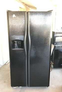 Side-by-side refrigerator with water and ice in door..