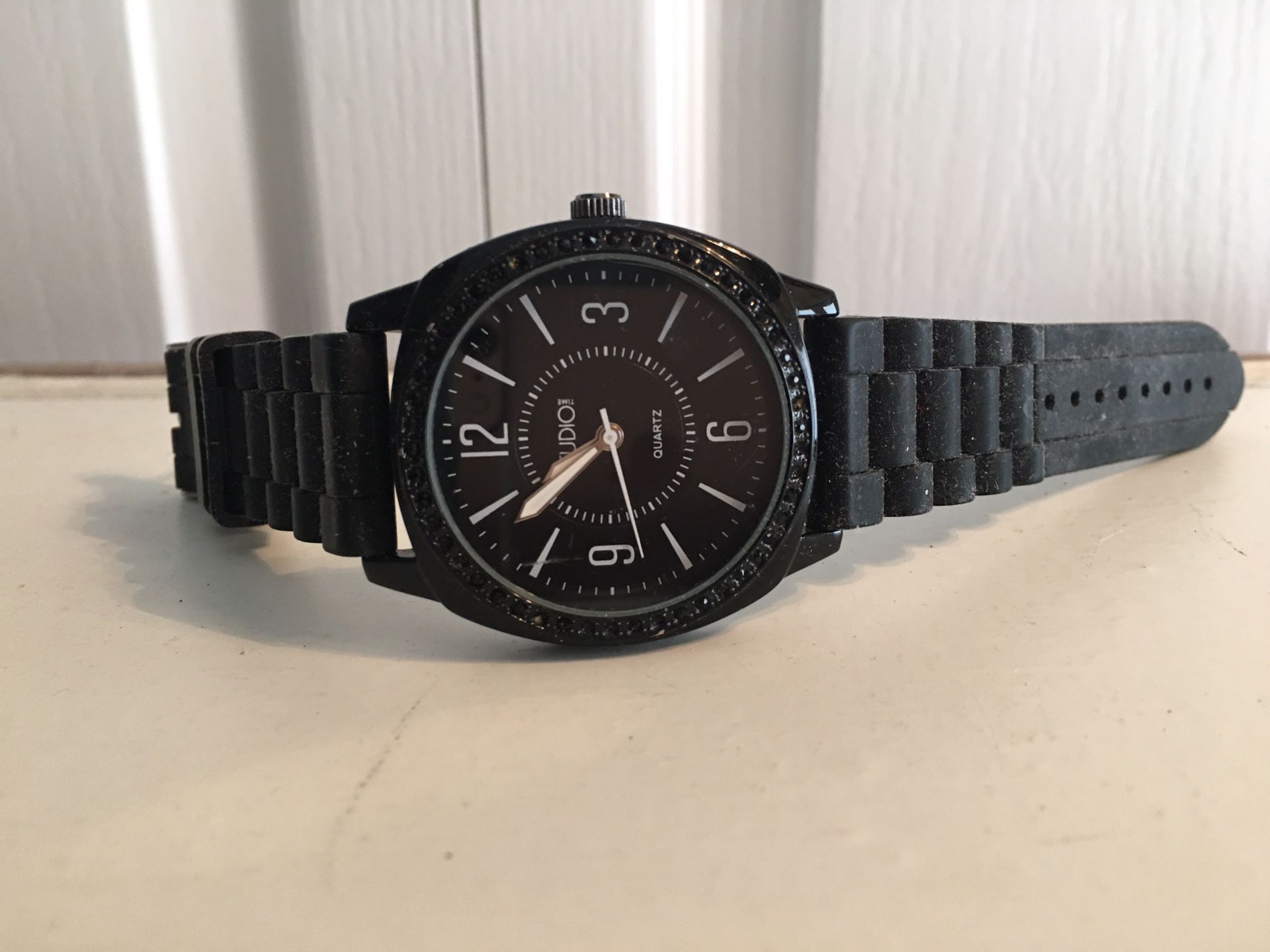 Women’s Studio Watch with woven rubber black band. Watch face is surrounded by black crystals. Never worn.