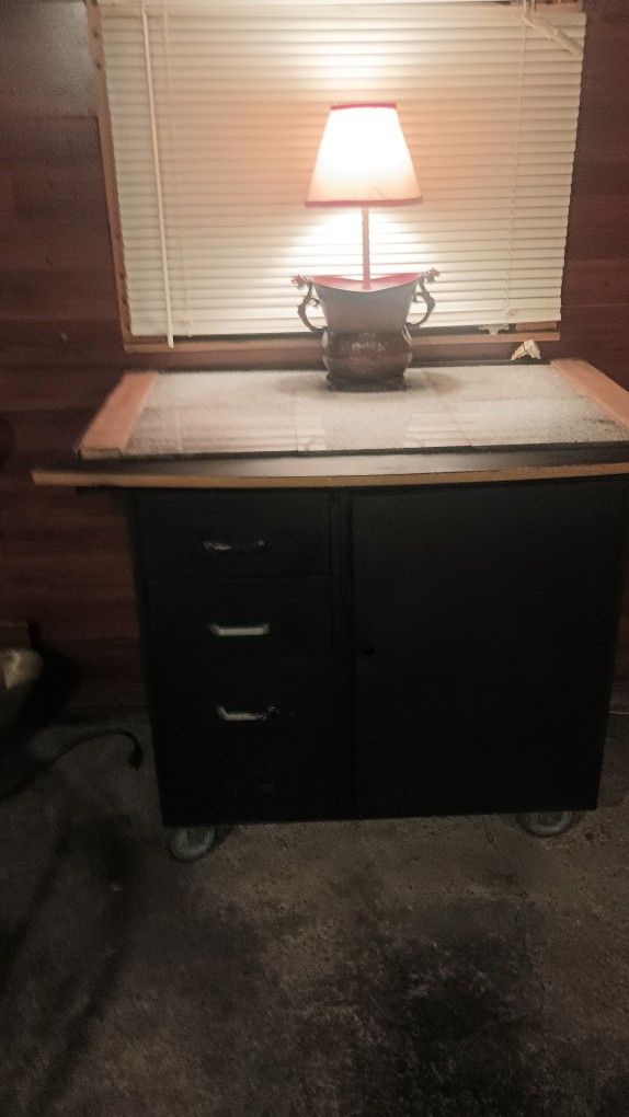 Movable Storage And Countertop. Body Is Black With mixed white and black Marble Tiles on Countertop.