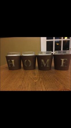 4 Candle holders spell the word HOME