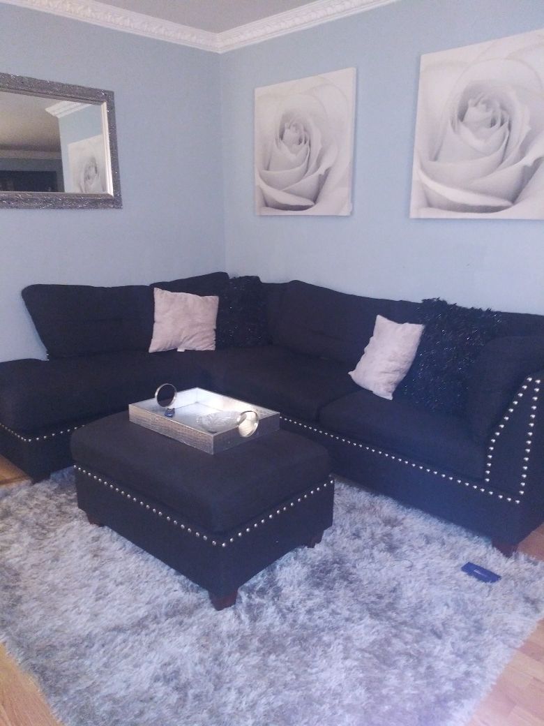 Black sectional with ottoman and two end tables