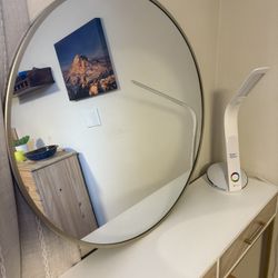 gold metal-framed round wall mirror