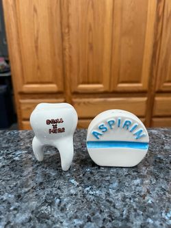 Ceramic Aspirin and Tooth pair of salt and pepper shakers.  Size approximately 2 1/2 inches tall.  Brand new never used with stickers.  Brand OCI.  Th