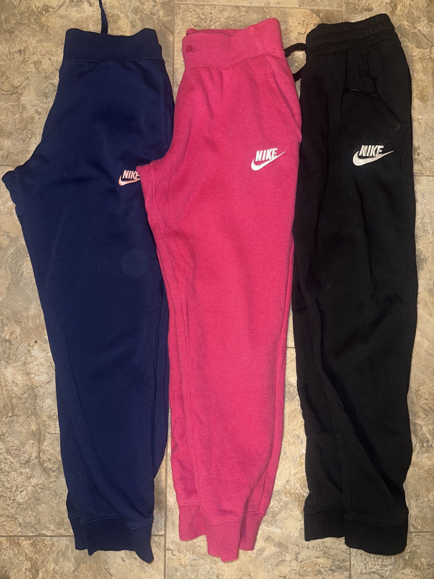 3 pairs of Nike big kid Joggers size large in hot pink, blue, and black