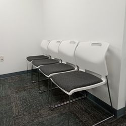 Designed To Stack, Built To Last! Used - White Frame Stacking Chair w/ grey Fabric Seat