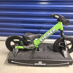 Strider 12” Sport Bike + Rocking Base - Helps Teach Baby How to Ride a Balance Bicycle - for Kids 6 Months to 4 Years