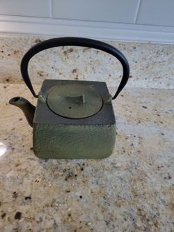 Metal green teapot.    I would say decorative.  Its been used alot.