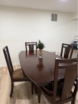 Brown wooden dining table with four chairs