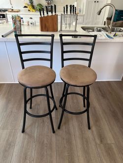 Pair of metal high chairs with tan cushions