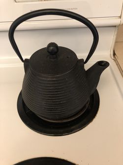 Heavy black iron tea kettle with strainer inside