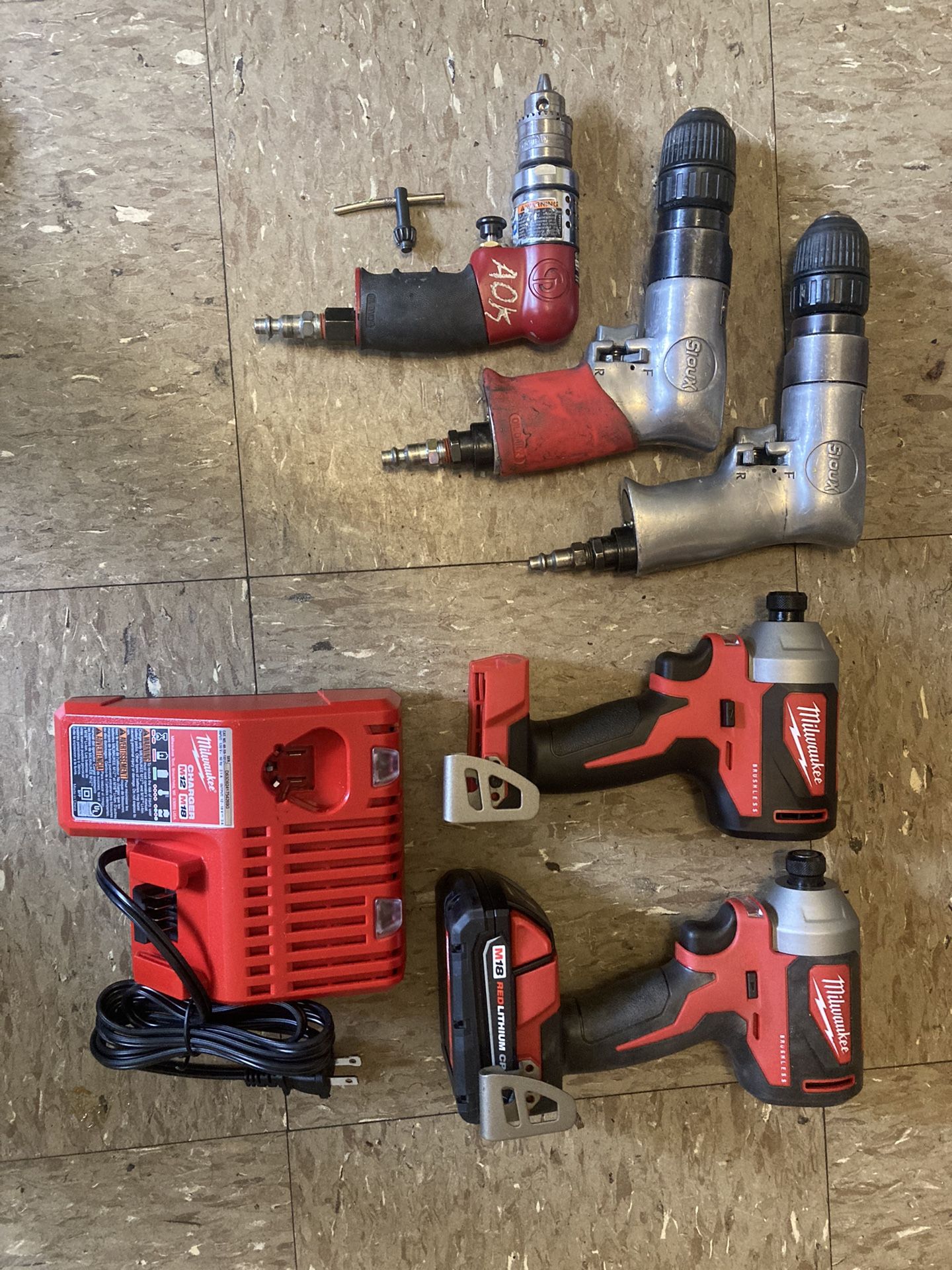 2 Milwaukee Impact Drills With One Battery And Charging Station140$,little Red Sioux Air Gun 150$,silver Sioux Air Drills 100$ Each