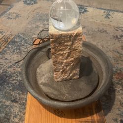 Beautiful Fountain Glass Ball Spins on Top Of The Stone Pillar 