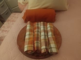 Four bronze colored chargers with four fall napkins and a rust cloth tablecloth from hobby lobby