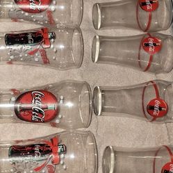 Vintage Coca-Cola Christmas glasses, specifically known for their festive "ribbon" or "snowflake and bottle" design. They were often released as promo