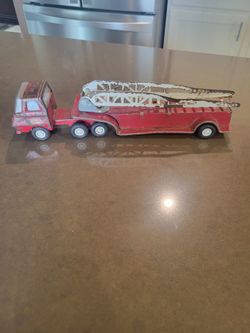 vintage red pressed- steel Tonka fire truck with a detachable trailer and an aerial ladder.