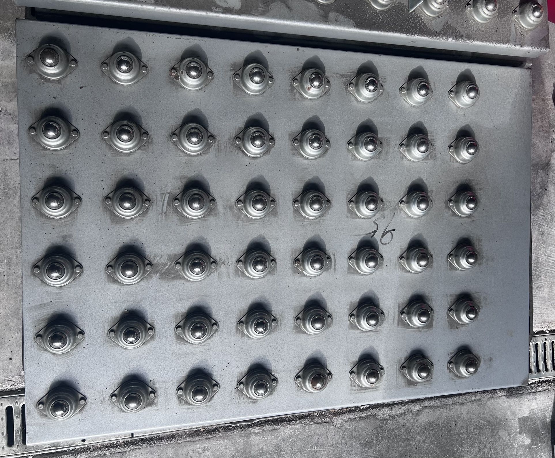 Heavy-duty steel ball transfer platform removed from an industrial conveyor system