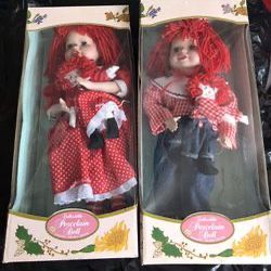 Raggedy Ann and Raggedy Andy. Each holding doll. New in boxes.