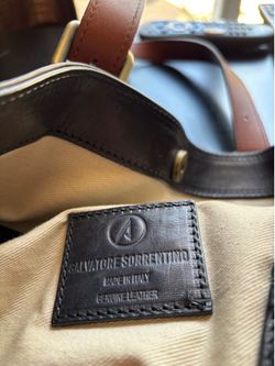 Genuine, leather black purse with brown strap.