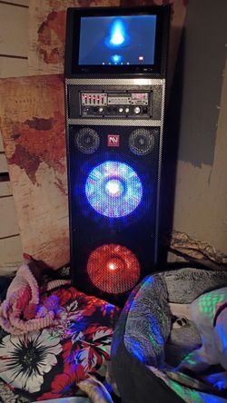 The item pictured is a Nutek WF-9122 Dual 12-Inch Professional Active Karaoke Speaker with a built-in touchscreen tablet.