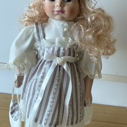 Porcelain Doll, 17” Tall, Purple & White Stripe Dress w/Lace & Blouse, Long Blonde Curly Hair w/Bow.