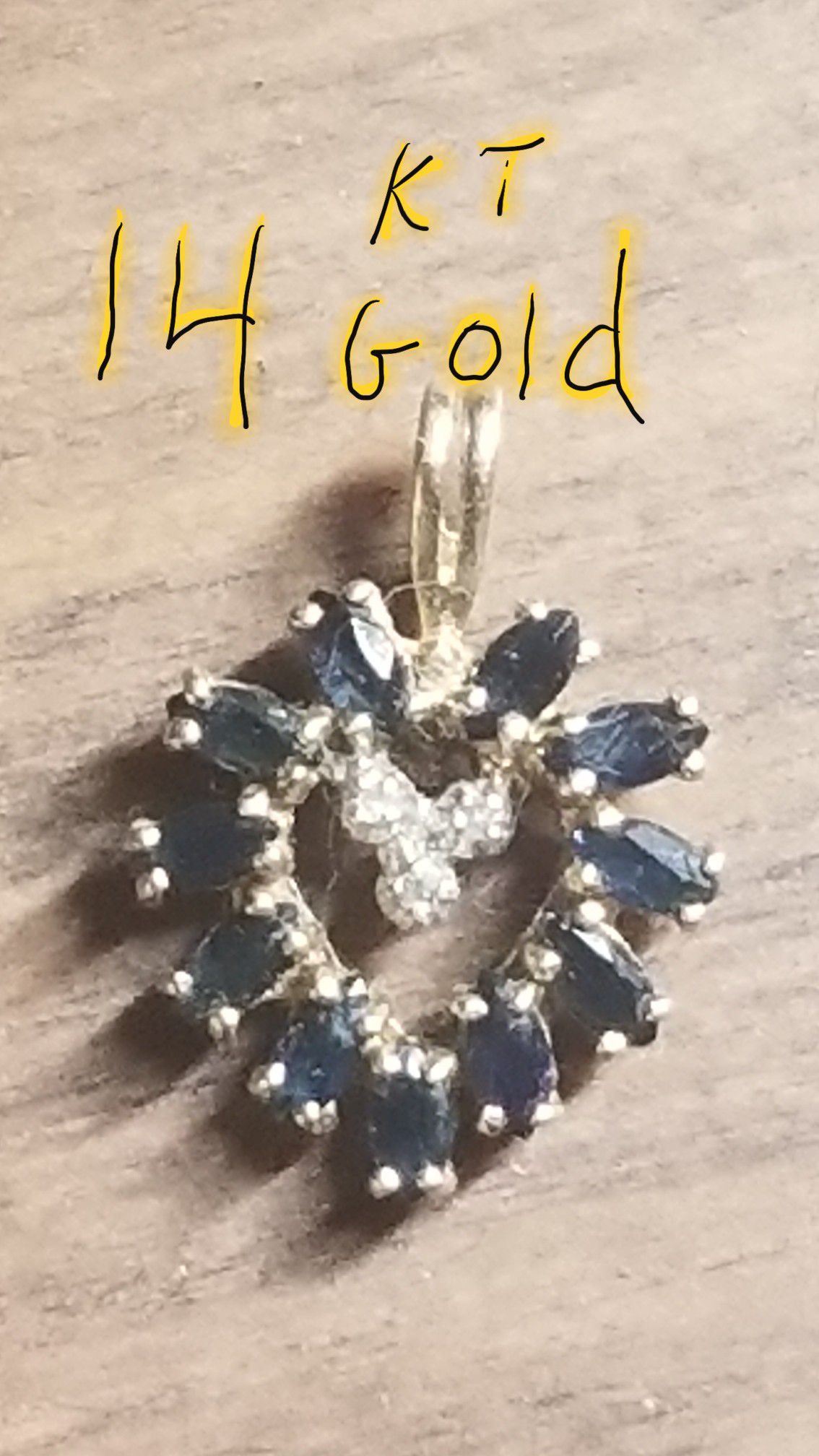 14 kt gold heart charm with 11 sapphires and 3 diamonds.