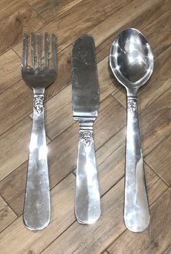 Oversized silverware trio consisting of a large fork, knife, and spoon kitchen or dining area wall decorations.