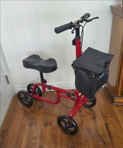 KNEE WALKER/SCOOTER: FOLDABLE.  ADJUSTABLE. FRONT POUCH. DUAL HAND BRAKES, BASKET.  RED FRAME. BRAKE LOCKING MECHANISM.  EXCELLENT CONDITION!