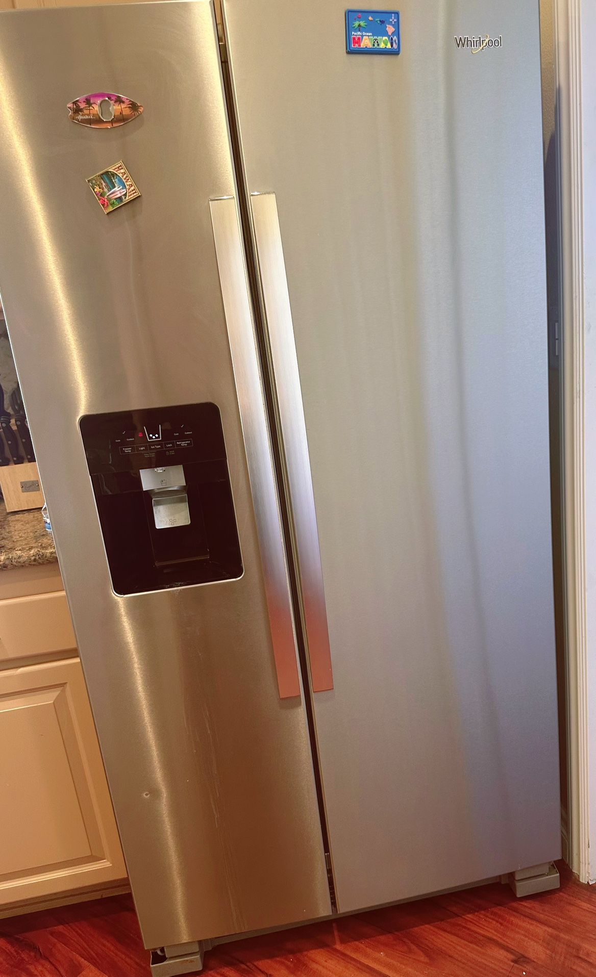 Whirlpool side-by-side refrigerator with a stainless steel finish and an exterior ice and water dispenser.