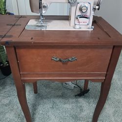 Vintage White Sewing Machine On Wood Cabinet 