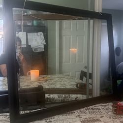 31 x 25 In, a wooden frame painted black with clear glass.