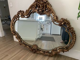 This piece is a large mid-century Hollywood Regency / Rococo Revival style horizontal wall mirror, manufactured by prominent vintage decor companies l
