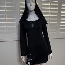 A sleek black long-sleeve mini dress with a fitted silhouette. Features lace-up grommet detail at the hem for an edgy finish. Lightweight, stretch fab