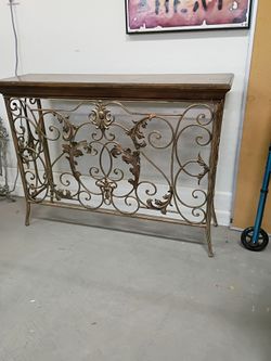 Ornate Wrought Iron Console Table and wood top. Gold tone base 12 in deep 42 wide and 32 inches tall nice heavy sturdy condition cash only please